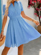 Vestido corto de mujer con cuello alto, cintura fruncida, mangas abullonadas y tejido texturizado. Perfecto para salidas informales y para lucir a la moda en verano.