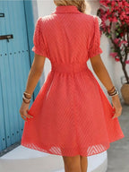 Vestido corto de mujer con cuello alto, cintura fruncida, mangas abullonadas y tejido texturizado. Perfecto para salidas informales y para lucir a la moda en verano.