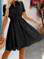 Vestido corto de mujer con cuello alto, cintura fruncida, mangas abullonadas y tejido texturizado. Perfecto para salidas informales y para lucir a la moda en verano.